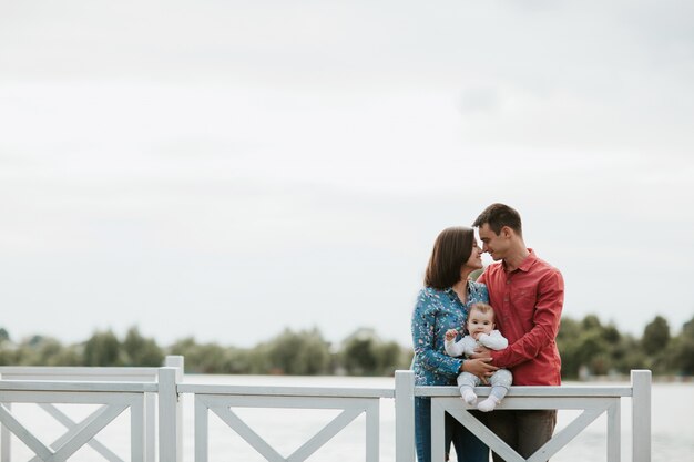 Familia feliz descansando junto al lago