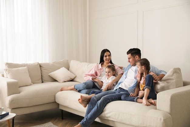 Família feliz descansando no sofá confortável na sala de estar