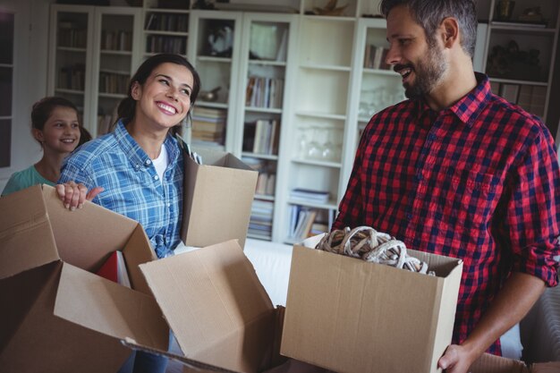 Familia feliz desempacando cajas de cartón juntas