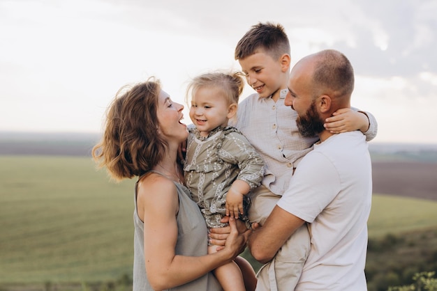 Família feliz desfrutando de tempo de qualidade juntos ao ar livre em um campo cênico
