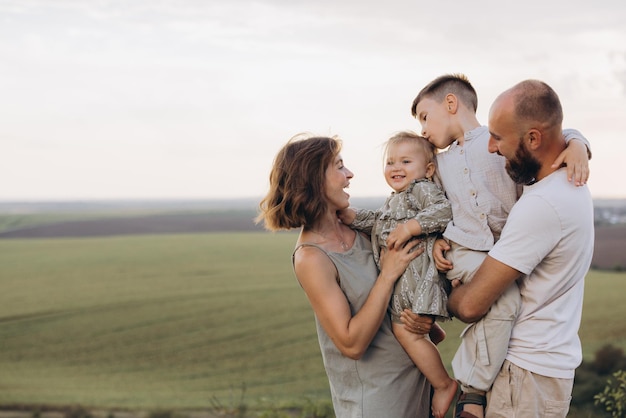 Família feliz desfrutando do tempo juntos ao ar livre na paisagem cênica do campo durante o dia ensolarado