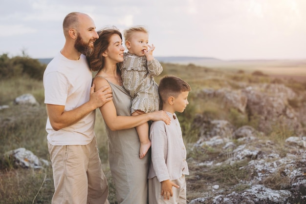 Família feliz desfrutando juntos da natureza durante um tranquilo pôr-do-sol no campo