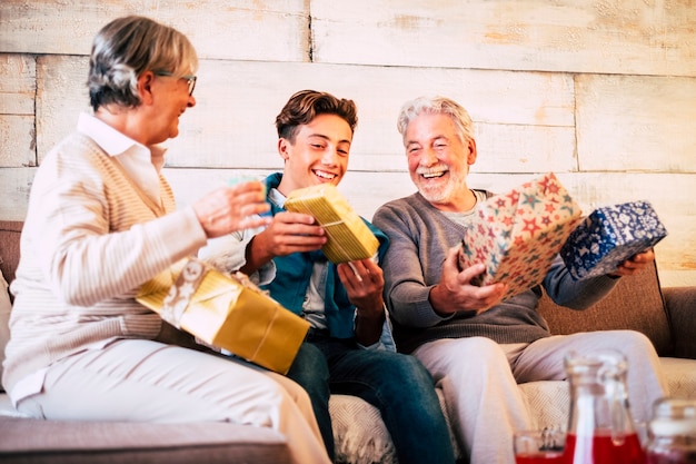 Familia feliz en el día de Nochebuena con abuelos y nietos divirtiéndose con intercambio de regalos