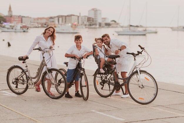 La familia feliz disfruta de una hermosa mañana junto al mar andando en bicicleta juntos y pasando tiempo juntos