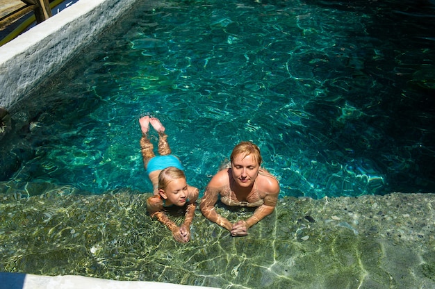 Una familia feliz disfruta de una piscina de tratamiento de sulfuro de hidrógeno en un resort en Turquía.