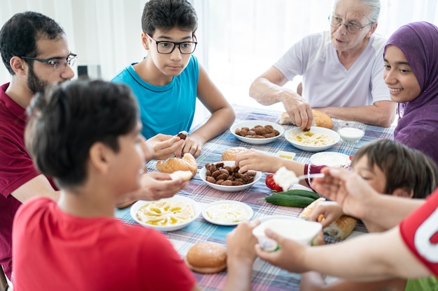 Familia feliz disfrutando de comer comida en el comedor