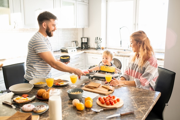 Familia feliz disfrutando del desayuno en la mañana