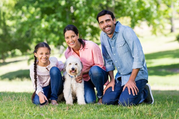 Familia feliz disfrutando junto con su perro mascota en el parque