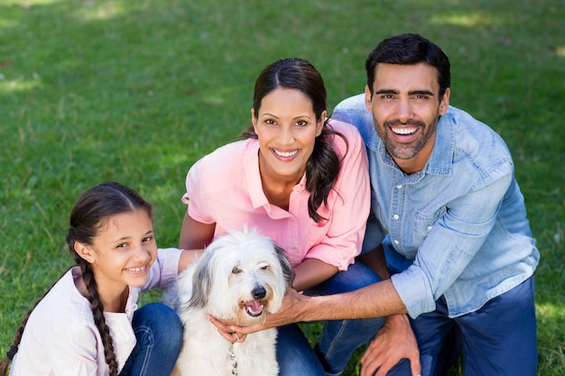 Familia feliz disfrutando junto con su perro mascota en el parque