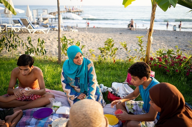 Familia feliz disfrutando de un picnic en la playa cerca del mar