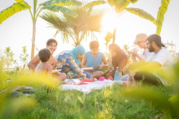 Familia feliz disfrutando de un picnic en la playa cerca del mar