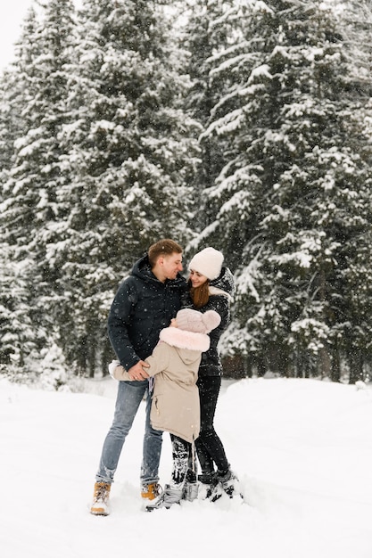 Familia feliz divertirse en el bosque de invierno. Madre, padre e hija, juego, con, snow., Familia, concepto