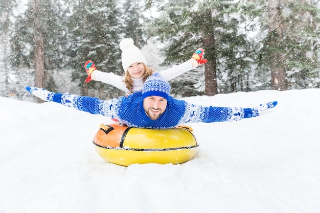 Familia feliz divirtiéndose al aire libre Niño y padre jugando en invierno Estilo de vida activo y saludable