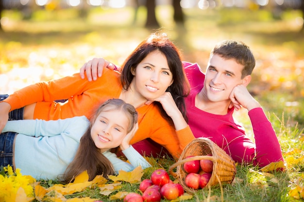 Familia feliz divirtiéndose al aire libre en el parque otoño