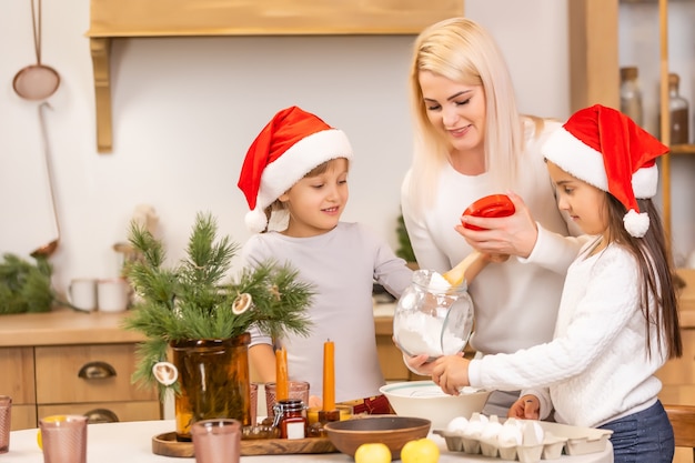 Familia feliz divirtiéndose en casa, cocina familiar antes de Navidad