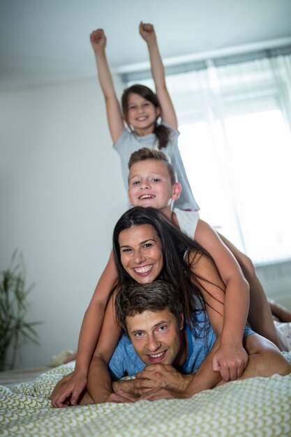 Familia feliz divirtiéndose en el dormitorio