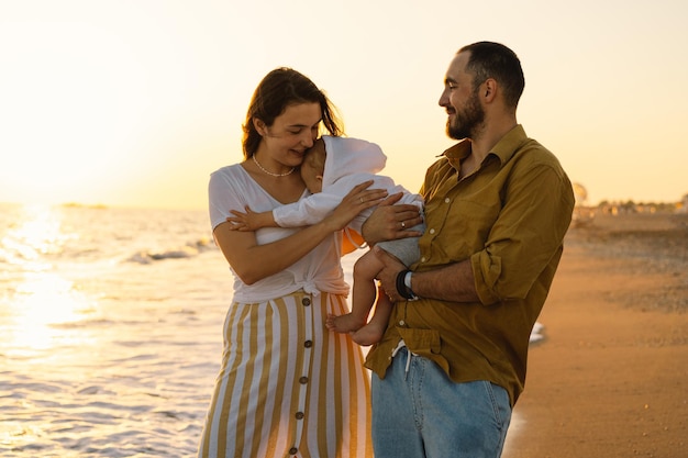 Familia feliz divirtiéndose jugando a la playa en vacaciones de verano en la playa Familia feliz y concepto de vacaciones Paisaje marino al atardecer con un hermoso cielo Familia en la playa