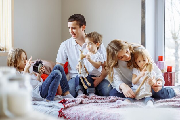 Familia feliz divirtiéndose juntos en casa en el dormitorio