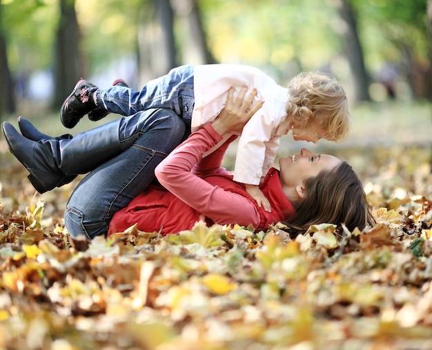 Familia feliz divirtiéndose en el parque otoño