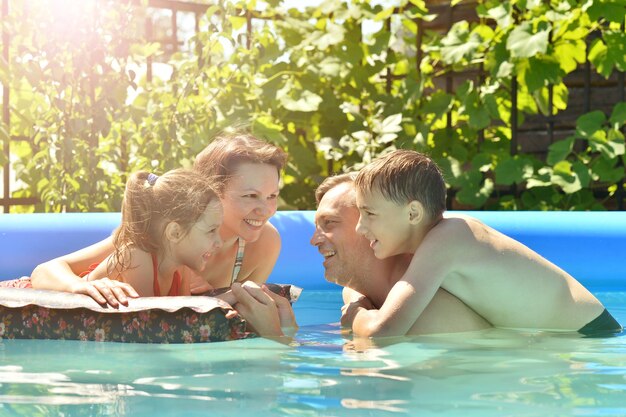 Familia feliz divirtiéndose en la piscina