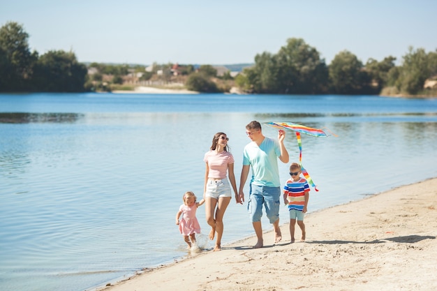 Familia feliz divirtiéndose en la playa.