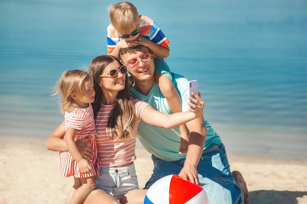 Familia feliz divirtiéndose en la playa