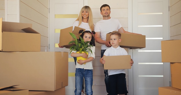 Familia feliz con dos hijos en casa nueva