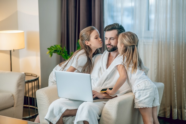 Familia feliz. Dos niñas mostrando su amor a papá y luciendo felices