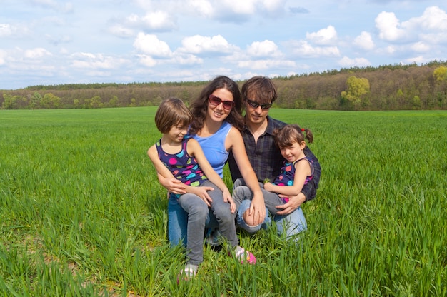 Familia feliz con dos niños en campo verde