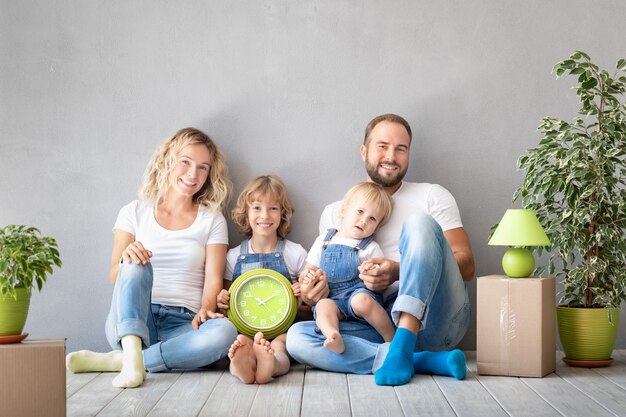 Familia feliz con dos niños jugando en casa nueva