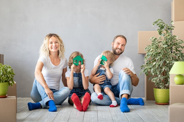 Familia feliz con dos niños jugando en casa nueva