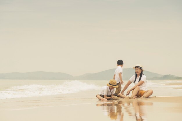 familia feliz con dos niños en la playa,