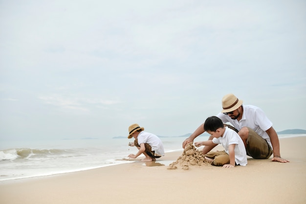 familia feliz con dos niños en la playa,