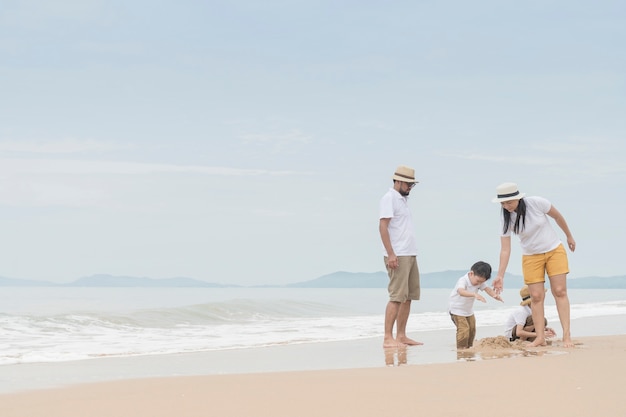 familia feliz con dos niños en la playa,