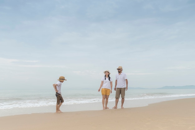 familia feliz con dos niños en la playa,