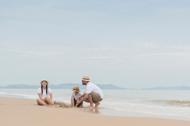 familia feliz con dos niños en la playa,