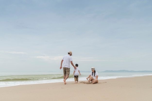 familia feliz con dos niños en la playa,