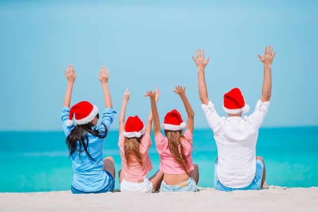 Foto familia feliz con dos niños en santa hat en vacaciones de verano