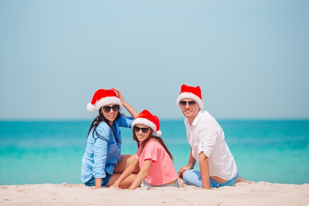 Familia feliz con dos niños en Santa Hat en vacaciones de verano