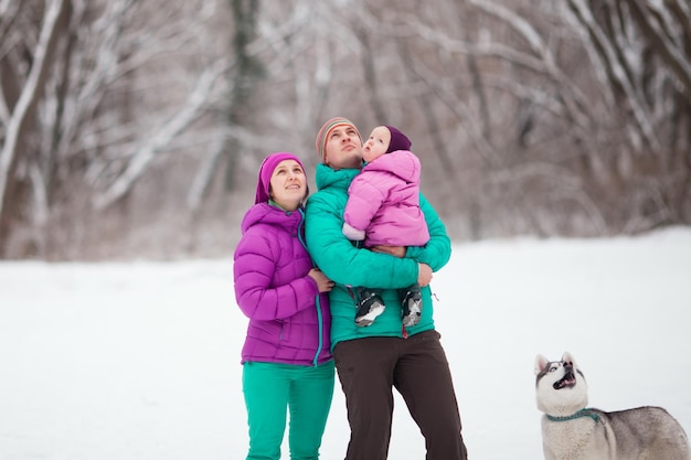 Família feliz e cachorro estão melhorando, dia frio de inverno no parque