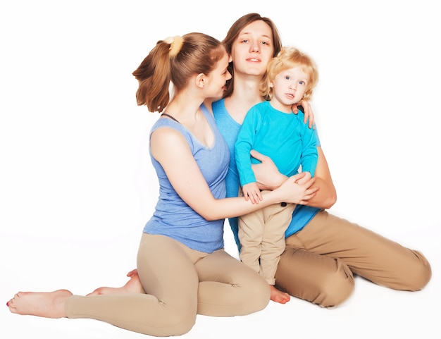 Família feliz e desportiva - mãe, pai e filho posando sobre fundo branco