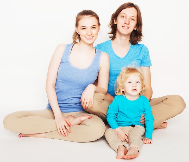 Família feliz e esportiva - mãe, pai e filho posando sobre o espaço em branco