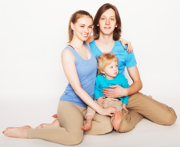 Família feliz e esportiva - mãe, pai e filho posando sobre o espaço em branco