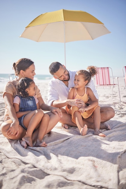 Família feliz e experiência de verão no oceano de um homem mãe e filhos curtindo o mar na areia Sorriso de felicidade de crianças e pessoas junto com tempo de qualidade sentado na natureza com um guarda-sol