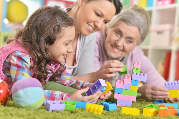 Família feliz e sorridente brincando com blocos de plástico coloridos