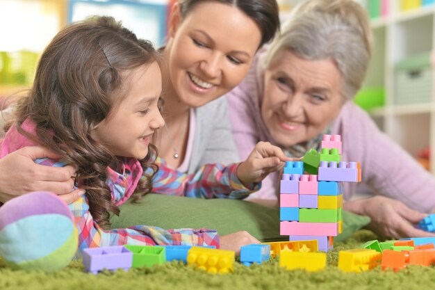 Família feliz e sorridente brincando com blocos de plástico coloridos