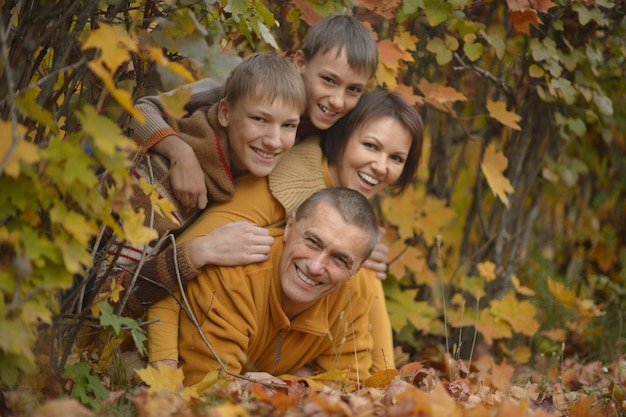 Família feliz e sorridente relaxando na floresta de outono