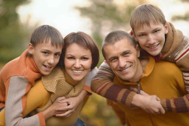 Família feliz e sorridente relaxando na floresta de outono