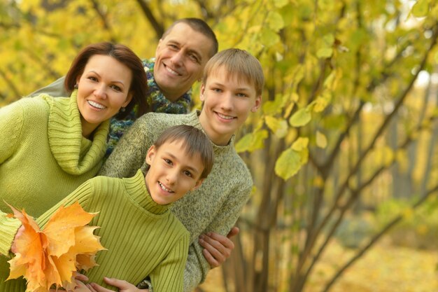 Família feliz e sorridente relaxando na floresta de outono