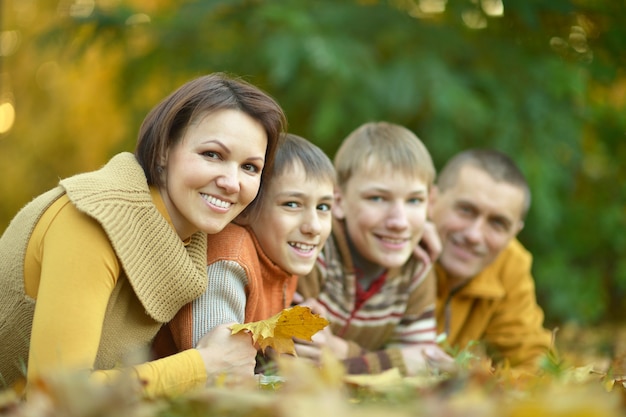 Família feliz e sorridente relaxando no parque de outono